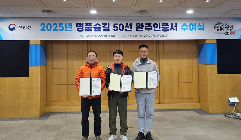 사진1. 산림청은 명품숲길 50선 전 구간을 완주한 참여자 23명에게 완주인증서를 수여했다. 수여식에 참석한 완주자 3명(왼쪽부터 이관표, 김남석, 이태곤)이 기념사진을 촬영하고 있다.jpg